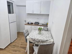 a kitchen with a table with a vase of flowers on it at Stan na dan Ilvento 2 in Vršac