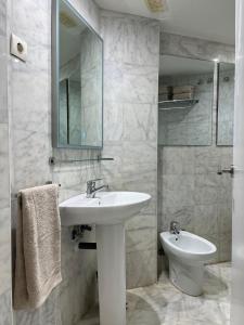Un baño con lavabo, espejo e inodoro. en Estudio Elena - Centro, en Torremolinos