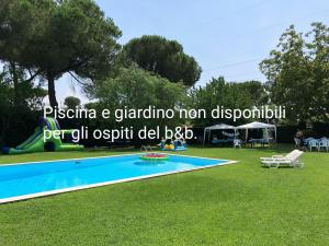 una piscina en la hierba con un cartel que dice piseria un grand en Vacanze Romane Olgiata, en La Storta