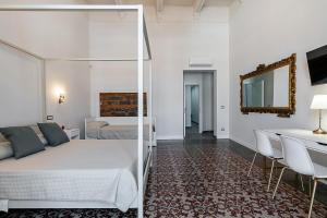a bedroom with a bed and a table and chairs at Il respiro di Encelado B&B in Catania