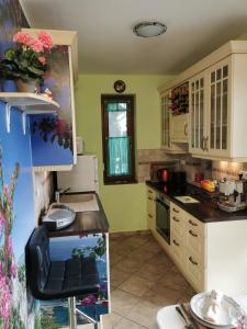 cocina con armarios blancos y encimera en Green Apple Guesthouse, en Leányfalu