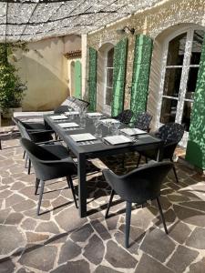 Une table à manger et des chaises noires sont disponibles sur la terrasse. dans l'établissement Villa St Endréol Golf & Spa I Piscine Chauffée I, à La Motte