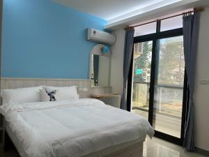 a bedroom with a large white bed and a window at 易宿輕旅民宿Easy Go B&B in Huxi