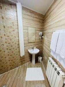 a bathroom with a sink and a mirror and towels at Casa Ștefan in Drobeta-Turnu Severin