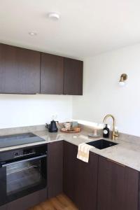 a kitchen with a sink and a stove top oven at Gäststuga 30 kv + loft in Vallentuna