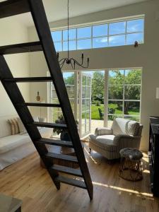 a living room with a spiral staircase in a house at Gäststuga 30 kv + loft in Vallentuna