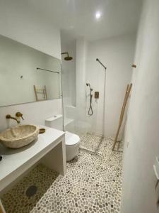 Baño blanco con lavabo y aseo en Doñana Suite Casa-Hotel, en El Rocío