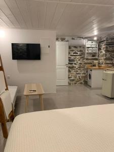 een kamer met een bed, een tafel en een keuken bij Artdecosyros Junior in Ano Syros