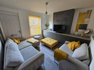 a living room with two couches and a tv at Jubilee House in Newark-on-Trent