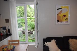 sala de estar con ventana y sofá en La Maison du Tourniquet, en Aubeterre-sur-Dronne