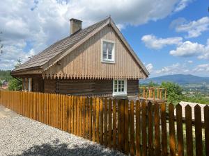 een klein huis achter een houten hek bij 120 letnia Chata w Górach z jacuzzi i sauną 