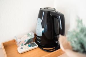 a black coffee maker and a remote control on a table at Drita Studios & Apartments in Svoronata