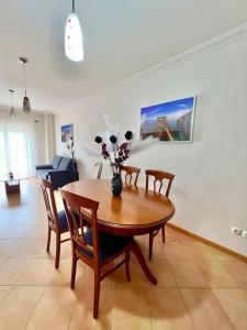 uma sala de estar com uma mesa de madeira e cadeiras em Appartement T2 avec vue panoramique sur la côte em Atouguia da Baleia