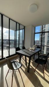 a dining room with a table and chairs and a large window at Wentworth Point Oversized balcony view apartment in Sydney