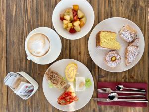 four plates of breakfast foods and a cup of coffee at I Bastioni San Domenico - Boutique Hotel in Gallipoli
