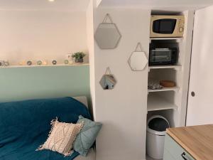 a living room with a blue couch and a microwave at Maison au calme à 25min de Paris in Dammarie-lès-Lys