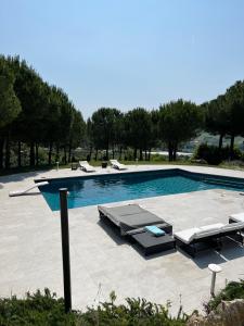 a large swimming pool with lounge chairs and a swimming poolvisor at GreenValley BnB in Lapedona