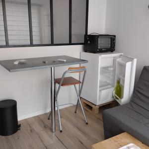 a small kitchen with a table and a microwave at Studio attenant a la maison principale in Saint-Martin-des-Tilleuls