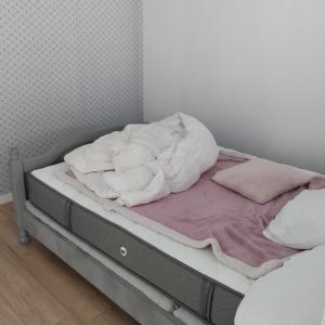 a bed with white sheets and pillows on it at Studio attenant a la maison principale in Saint-Martin-des-Tilleuls