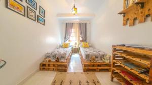 - une chambre avec 2 lits et une fenêtre dans l'établissement Appart Ayoub, à Essaouira