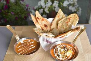 Swastik Resort Tajpur في Tajpur: طاولة مقدمة مع طبقين من الطعام والغطس