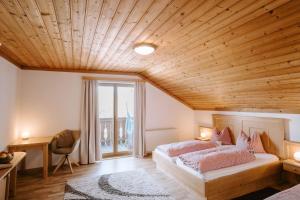ein Schlafzimmer mit zwei Betten und einer Holzdecke in der Unterkunft Feichtingerhof in Steinbach am Attersee