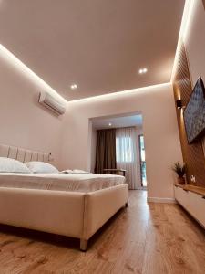 1 dormitorio grande con 1 cama grande y TV en Beach Apartaments Durres, en Durrës