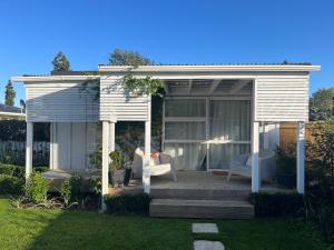 a white gazebo with two chairs on a lawn at Boutique French Central Matamata in Matamata