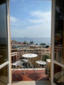 een balkon met een tafel en stoelen en uitzicht op de oceaan bij Hotel Pineta in Laigueglia