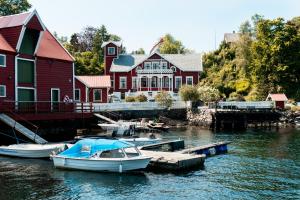a group of boats docked in the water in front of a house at VILLA BRATTHOLMEN in Brattholmen