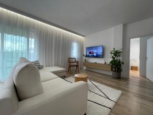 a living room with a white couch and a tv at Myslym Shyri's Apartments in Tirana