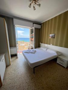 a bedroom with a bed with a view of the ocean at Hotel Pineta in Laigueglia