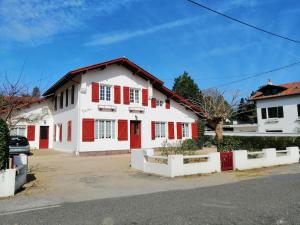 Casa blanca y roja con persianas rojas en Maison au coeur d’Arcangues, proximité de Biarritz, en Arcangues