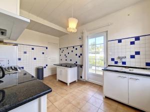 cocina grande con azulejos azules y blancos en las paredes en Maison au coeur d’Arcangues, proximité de Biarritz, en Arcangues