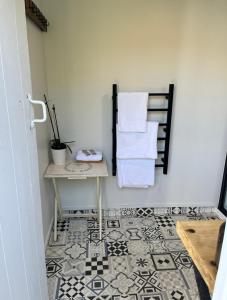 a bathroom with a table and towels on a wall at Central Matamata Boutique in Matamata