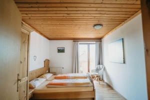 ein Schlafzimmer mit zwei Betten und einer Holzdecke in der Unterkunft Feichtingerhof in Steinbach am Attersee