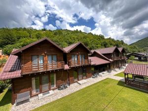 una gran casa de madera con un patio verde en Relax and Smile Rameț, en Biceşti