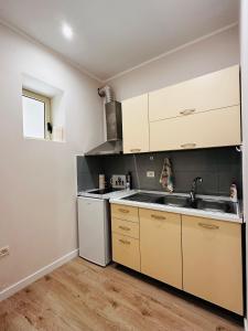 a kitchen with white cabinets and a sink at Beach Apartaments Durres in Durrës