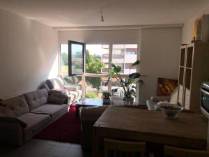 a living room with a couch and a table at One bedroom 3pieces entire Modern Appartment close to Airport, CERN, Palexpo, public transport to the center of Geneva in Meyrin