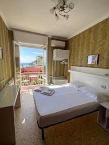 a bedroom with a bed and a view of a balcony at Hotel Pineta in Laigueglia