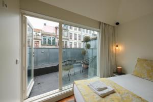 une chambre avec un lit et une grande fenêtre dans l'établissement Impar Luxury Apartments, à Porto