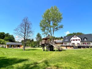 dom na polu z zieloną trawą i drzewem w obiekcie Lighthouse w mieście Grafengehaig