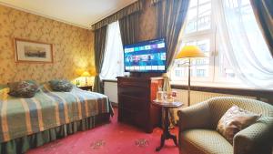 グダニスクにあるホテル ポデヴィルスのベッド1台、薄型テレビが備わるホテルルームです。