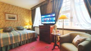 a hotel room with a bed and a flat screen tv at Podewils Old Town Gdansk in Gdańsk