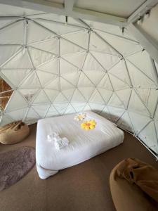 ein Zimmer mit einer weißen Matratze mit Blumen darauf in der Unterkunft สะปันดีวิว Sapan Dee View บ่อเกลือ น่าน in Ban Huai Ti