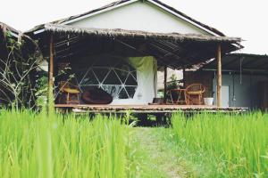 ein Haus mit einer Veranda und Stühlen im Hof in der Unterkunft สะปันดีวิว Sapan Dee View บ่อเกลือ น่าน in Ban Huai Ti