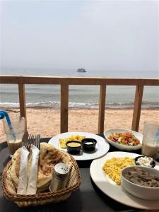 einen Tisch mit Teller mit Speisen am Strand in der Unterkunft Sinai Life Beach Camp in Nuweiba