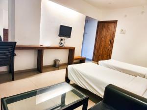een kamer met 2 bedden en een tv aan de muur bij Hotel Rajwada Aurangabad in Aurangabad