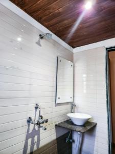 a bathroom with a sink and a mirror at Hotel Rajwada Aurangabad in Aurangabad