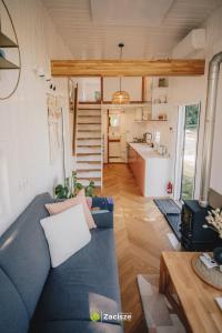 プシビツにあるPółwysep Zacisze - Tiny House Villageのリビングルーム(青いソファ付)、キッチン